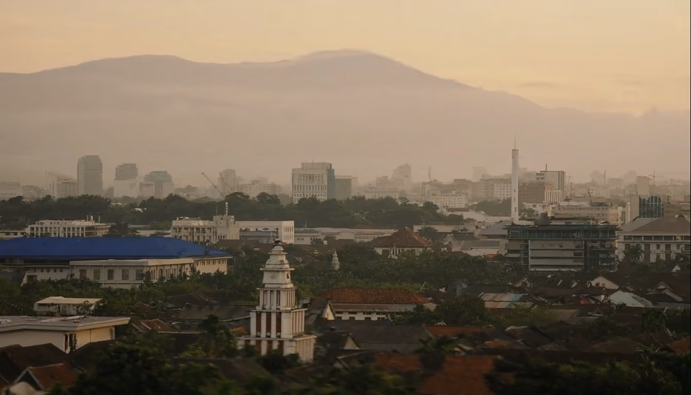Indonesian secondary city skyline at golden hour with distant mountains