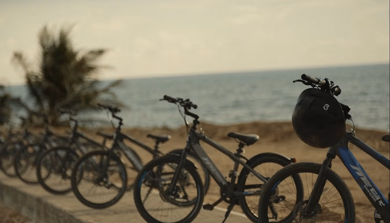 Row of electric bicycles along Indonesian beachfront path at golden hour